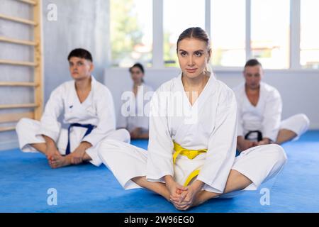 Gruppo di uomini e donne in kimono che fanno la farfalla posa in studio. Foto Stock