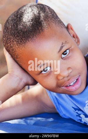 bambino africano nel villaggio riposa all'aperto nel cortile Foto Stock