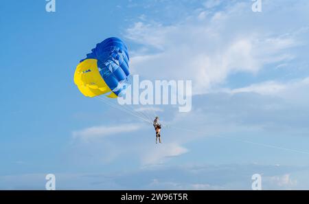 Il turista sta sta godendo un giro in paracadutismo ascensionale sulla spiaggia di Patong a Phuket in Thailandia. Sport acquatici Foto Stock