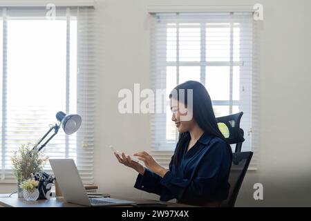 Giovane donna d'affari asiatica che usa una calcolatrice per calcolare il principio di business. Concetto di statistiche contabili in ufficio Foto Stock