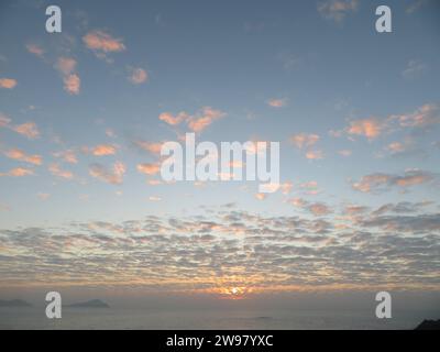 Una vista mozzafiato di una pittoresca costa, al tramonto che illumina le tranquille acque sottostanti Foto Stock