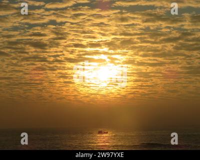 Una vista mozzafiato di una pittoresca costa, al tramonto che illumina le tranquille acque sottostanti Foto Stock