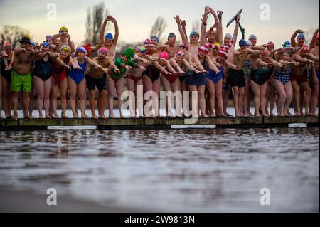 I nuotatori si riuniscono presto per la tradizionale gara di nuoto mattutina di Natale del Regno Unito nel lago Serpentine di Londra, Hyde Park. Chiamati i nuotatori della Peter Pan Cup hanno gareggiato nei cappelli di Babbo Natale dal 1864. Alle 9:00, i membri del Serpentine Swimming Club si tuffano nell'acqua ghiacciata di 7 gradi centigradi per correre per 100 metri (91 metri). L'autore J M Barrie, che viveva nelle vicinanze, Peter Pan, è stato associato alla gara di Natale del 1903. Foto Stock