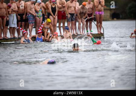 I nuotatori si riuniscono presto per la tradizionale gara di nuoto mattutina di Natale del Regno Unito nel lago Serpentine di Londra, Hyde Park. Chiamati i nuotatori della Peter Pan Cup hanno gareggiato nei cappelli di Babbo Natale dal 1864. Alle 9:00, i membri del Serpentine Swimming Club si tuffano nell'acqua ghiacciata di 7 gradi centigradi per correre per 100 metri (91 metri). L'autore J M Barrie, che viveva nelle vicinanze, Peter Pan, è stato associato alla gara di Natale del 1903. Foto Stock