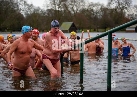 I nuotatori si riuniscono presto per la tradizionale gara di nuoto mattutina di Natale del Regno Unito nel lago Serpentine di Londra, Hyde Park. Chiamati i nuotatori della Peter Pan Cup hanno gareggiato nei cappelli di Babbo Natale dal 1864. Alle 9:00, i membri del Serpentine Swimming Club si tuffano nell'acqua ghiacciata di 7 gradi centigradi per correre per 100 metri (91 metri). L'autore J M Barrie, che viveva nelle vicinanze, Peter Pan, è stato associato alla gara di Natale del 1903. Foto Stock