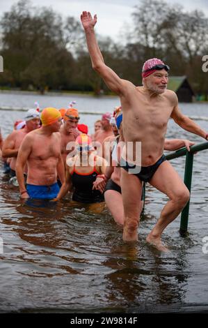 I nuotatori si riuniscono presto per la tradizionale gara di nuoto mattutina di Natale del Regno Unito nel lago Serpentine di Londra, Hyde Park. Chiamati i nuotatori della Peter Pan Cup hanno gareggiato nei cappelli di Babbo Natale dal 1864. Alle 9:00, i membri del Serpentine Swimming Club si tuffano nell'acqua ghiacciata di 7 gradi centigradi per correre per 100 metri (91 metri). L'autore J M Barrie, che viveva nelle vicinanze, Peter Pan, è stato associato alla gara di Natale del 1903. Foto Stock