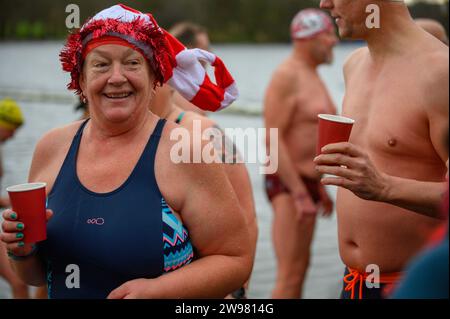 I nuotatori si riuniscono presto per la tradizionale gara di nuoto mattutina di Natale del Regno Unito nel lago Serpentine di Londra, Hyde Park. Chiamati i nuotatori della Peter Pan Cup hanno gareggiato nei cappelli di Babbo Natale dal 1864. Alle 9:00, i membri del Serpentine Swimming Club si tuffano nell'acqua ghiacciata di 7 gradi centigradi per correre per 100 metri (91 metri). L'autore J M Barrie, che viveva nelle vicinanze, Peter Pan, è stato associato alla gara di Natale del 1903. Foto Stock