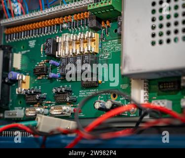 Un primo piano di una varietà di cavi elettrici, cavi e fili all'interno di un armadio elettronico Foto Stock