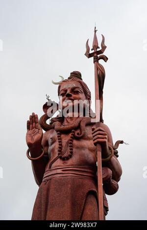 Statua del Signore Rosso Shiva con Tridente a Ganga Talao o Grand Bassin Mauritius Foto Stock