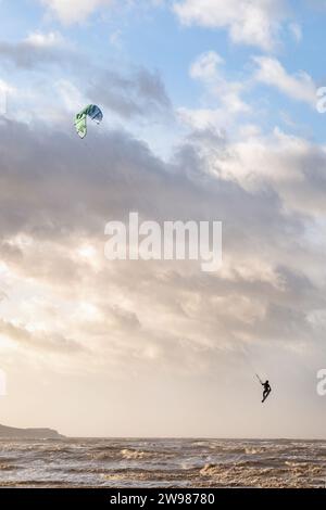 Weston super Mare, Regno Unito. Un Kitesurfer o Kiteboarder sfrutta i forti venti durante Storm Pia per fare un salto in alto sulle onde del mare Foto Stock