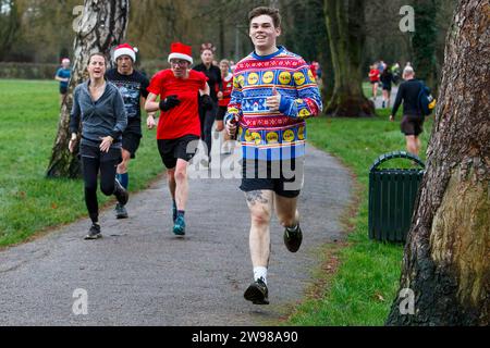 Chippenham, Wiltshire, Regno Unito. 25 dicembre 2023. I corridori sono fotografati mentre prendono parte a una corsa di 5 km nel parco di Monkton Park, Chippenham, il giorno di Natale di prima mattina. La partenza anticipata non ha fatto nulla per attenuare lo spirito natalizio delle 200-300 persone che hanno partecipato all'evento, molte delle quali si sono vestite con abiti eleganti. Credito: Lynchpics/Alamy Live News Foto Stock