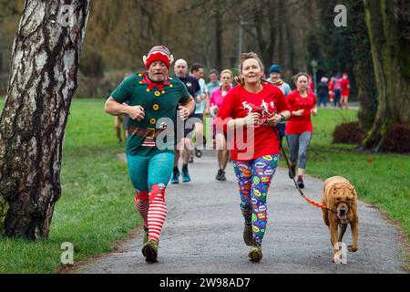 Chippenham, Wiltshire, Regno Unito. 25 dicembre 2023. I corridori sono fotografati mentre prendono parte a una corsa di 5 km nel parco di Monkton Park, Chippenham, il giorno di Natale di prima mattina. La partenza anticipata non ha fatto nulla per attenuare lo spirito natalizio delle 200-300 persone che hanno partecipato all'evento, molte delle quali si sono vestite con abiti eleganti. Credito: Lynchpics/Alamy Live News Foto Stock