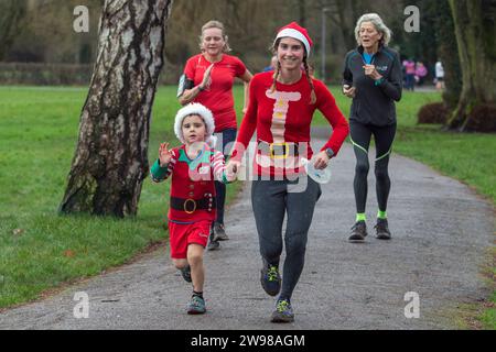 Chippenham, Wiltshire, Regno Unito. 25 dicembre 2023. I corridori sono fotografati mentre prendono parte a una corsa di 5 km nel parco di Monkton Park, Chippenham, il giorno di Natale di prima mattina. La partenza anticipata non ha fatto nulla per attenuare lo spirito natalizio delle 200-300 persone che hanno partecipato all'evento, molte delle quali si sono vestite con abiti eleganti. Credito: Lynchpics/Alamy Live News Foto Stock