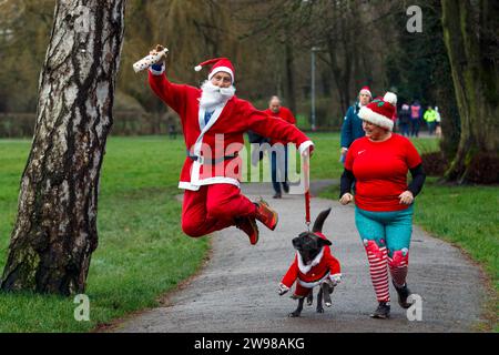 Chippenham, Wiltshire, Regno Unito. 25 dicembre 2023. I corridori sono fotografati mentre prendono parte a una corsa di 5 km nel parco di Monkton Park, Chippenham, il giorno di Natale di prima mattina. La partenza anticipata non ha fatto nulla per attenuare lo spirito natalizio delle 200-300 persone che hanno partecipato all'evento, molte delle quali si sono vestite con abiti eleganti. Credito: Lynchpics/Alamy Live News Foto Stock