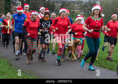 Chippenham, Wiltshire, Regno Unito. 25 dicembre 2023. I corridori sono fotografati mentre prendono parte a una corsa di 5 km nel parco di Monkton Park, Chippenham, il giorno di Natale di prima mattina. La partenza anticipata non ha fatto nulla per attenuare lo spirito natalizio delle 200-300 persone che hanno partecipato all'evento, molte delle quali si sono vestite con abiti eleganti. Credito: Lynchpics/Alamy Live News Foto Stock