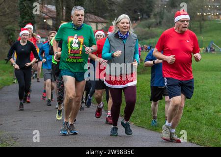 Chippenham, Wiltshire, Regno Unito. 25 dicembre 2023. I corridori sono fotografati mentre prendono parte a una corsa di 5 km nel parco di Monkton Park, Chippenham, il giorno di Natale di prima mattina. La partenza anticipata non ha fatto nulla per attenuare lo spirito natalizio delle 200-300 persone che hanno partecipato all'evento, molte delle quali si sono vestite con abiti eleganti. Credito: Lynchpics/Alamy Live News Foto Stock