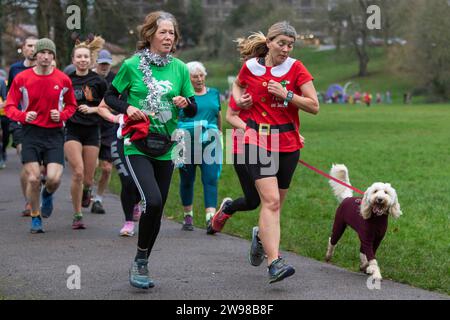 Chippenham, Wiltshire, Regno Unito. 25 dicembre 2023. I corridori sono fotografati mentre prendono parte a una corsa di 5 km nel parco di Monkton Park, Chippenham, il giorno di Natale di prima mattina. La partenza anticipata non ha fatto nulla per attenuare lo spirito natalizio delle 200-300 persone che hanno partecipato all'evento, molte delle quali si sono vestite con abiti eleganti. Credito: Lynchpics/Alamy Live News Foto Stock