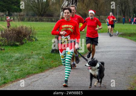 Chippenham, Wiltshire, Regno Unito. 25 dicembre 2023. I corridori sono fotografati mentre prendono parte a una corsa di 5 km nel parco di Monkton Park, Chippenham, il giorno di Natale di prima mattina. La partenza anticipata non ha fatto nulla per attenuare lo spirito natalizio delle 200-300 persone che hanno partecipato all'evento, molte delle quali si sono vestite con abiti eleganti. Credito: Lynchpics/Alamy Live News Foto Stock