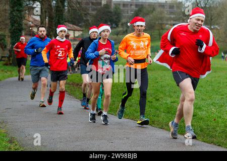 Chippenham, Wiltshire, Regno Unito. 25 dicembre 2023. I corridori sono fotografati mentre prendono parte a una corsa di 5 km nel parco di Monkton Park, Chippenham, il giorno di Natale di prima mattina. La partenza anticipata non ha fatto nulla per attenuare lo spirito natalizio delle 200-300 persone che hanno partecipato all'evento, molte delle quali si sono vestite con abiti eleganti. Credito: Lynchpics/Alamy Live News Foto Stock