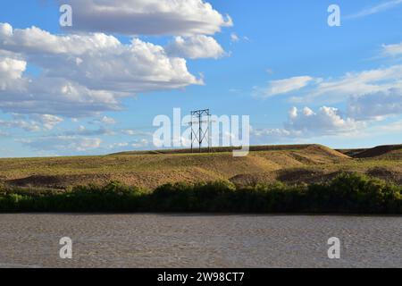 Un palo di trasmissione elettrica in legno in piedi su una collina erbosa vicino al Green River nello Utah Foto Stock