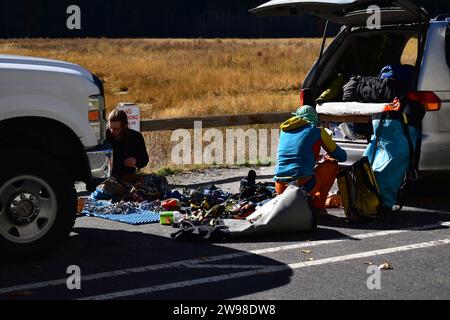 Gli scalatori selezionano e preparano l'attrezzatura da arrampicata tra le auto parcheggiate nella Yosemite Valley Foto Stock