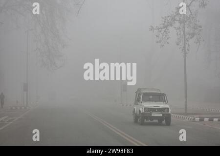 Srinagar, India. 25 dicembre 2023. Un veicolo si muove lungo la strada durante una nebbia a Srinagar, la capitale estiva del Jammu e del Kashmir. (Foto di Saqib Majeed/SOPA Images/Sipa USA) credito: SIPA USA/Alamy Live News Foto Stock