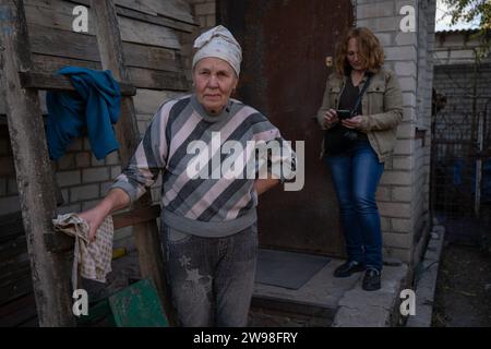 Kupiansk, Ucraina. 5 ottobre 2023. Nadiia Dehtiarova (75), con sua figlia Iryna Sizonova (50) di fronte alla loro casa sulla riva sinistra, a circa 5 km dal fronte. Il 10 settembre 2023, le autorità ucraine hanno annunciato l'evacuazione obbligatoria degli insediamenti nell'area di Kupiansk, sulla riva orientale del fiume Oskol'", comprese parti della stessa Kupiansk. Meno di un anno dopo essere stata liberata dall'esercito ucraino, la città e i suoi sobborghi, essendo un importante nodo ferroviario e stradale collegato direttamente alla Russia stessa, divennero nuovamente un importante obiettivo militare, in pericolo Foto Stock