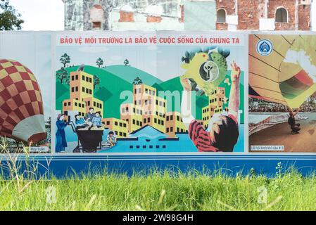 Da Nang, Vietnam - 7 ottobre 2023: Un poster "proteggere l'ambiente sta proteggendo le nostre vite" su un recinto di costruzione. Foto Stock