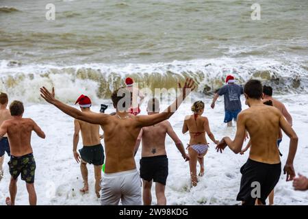 In mezzo all'allegria festiva e alle vivaci celebrazioni sulla spiaggia di Brighton, dove centinaia di persone si sono riunite per l'annuale giorno di Natale nuotano nel grezzo cahnnel inglese dove la temperatura era di 10,4 m. Foto Stock