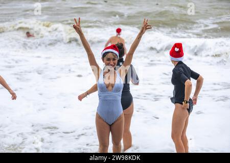 In mezzo all'allegria festiva e alle vivaci celebrazioni sulla spiaggia di Brighton, dove centinaia di persone si sono riunite per l'annuale giorno di Natale nuotano nel grezzo cahnnel inglese dove la temperatura era di 10,4 m. Foto Stock