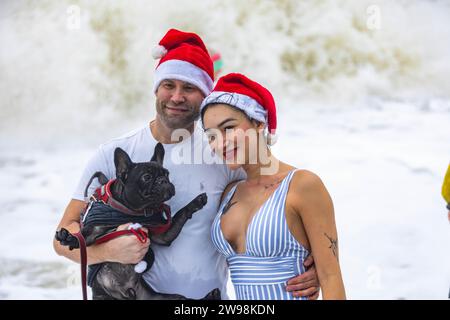 In mezzo all'allegria festiva e alle vivaci celebrazioni sulla spiaggia di Brighton, dove centinaia di persone si sono riunite per l'annuale giorno di Natale nuotano nel grezzo cahnnel inglese dove la temperatura era di 10,4 m. Foto Stock