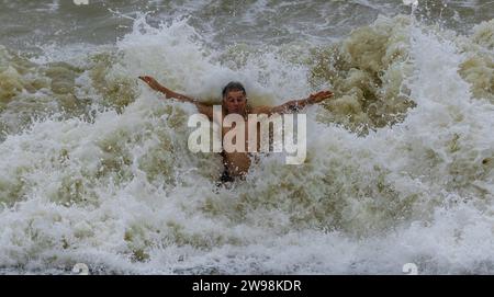 In mezzo all'allegria festiva e alle vivaci celebrazioni sulla spiaggia di Brighton, dove centinaia di persone si sono riunite per l'annuale giorno di Natale nuotano nel grezzo cahnnel inglese dove la temperatura era di 10,4 m. Foto Stock