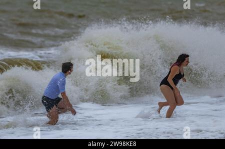 In mezzo all'allegria festiva e alle vivaci celebrazioni sulla spiaggia di Brighton, dove centinaia di persone si sono riunite per l'annuale giorno di Natale nuotano nel grezzo cahnnel inglese dove la temperatura era di 10,4 m. Foto Stock