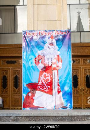 Poster di buon anno natalizio in Uzbekistan con Babbo Natale o Father Frost che decorano il Musical Theatre in Kuk Saroy Square a Samarcanda Foto Stock