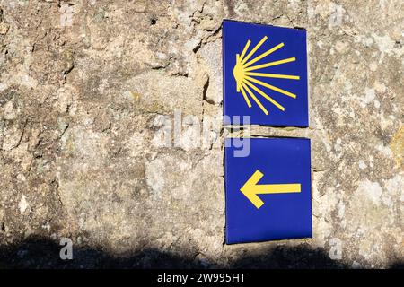 Un primo piano delle piastrelle di Camino de Santiago su un antico muro di pietra Foto Stock