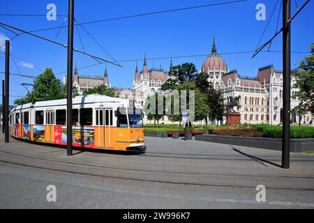 Tram n.. 23 passando accanto all'edificio del Parlamento ungherese a Budapest, Ungheria Foto Stock