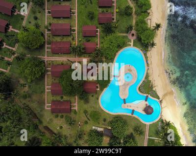 Vista aerea su una piscina a forma di cuore e bungalow sull'isola di Ilheu das Rolas, Sao Tomé e Principe, Africa Foto Stock