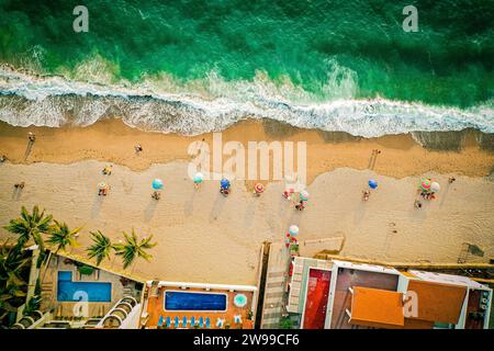 Foto aerea dall'alto verso il basso della spiaggia e dell'oceano colorato con ombrelloni Foto Stock