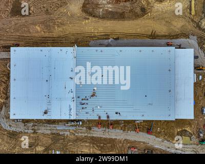 Una vista dall'alto della base di un vasto impianto industriale, con materiali e macchine movimento terra che punteggiano la prima costruzione Foto Stock