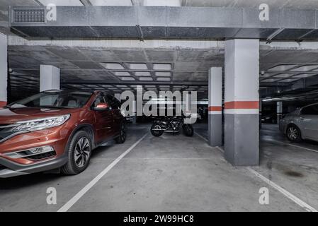 Garage sotterraneo di un edificio residenziale con diversi spazi vuoti Foto Stock