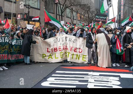 New York, USA. 25 dicembre 2023. Centinaia di manifestanti pro-palestinesi si radunano a Rockefeller plaza e marciano intorno a Midtown a New York il 25 dicembre 2023 come chiamavano "Christmas is cancellated Protest". I membri della LGBTQ si unirono ai manifestanti. I manifestanti hanno cantato slogan per liberare la Palestina e alcuni hanno persino glorificato Hamas per il loro attacco terroristico contro Israele durante il quale hanno ucciso più di 900 civili, tra cui bambini, donne e anziani, donne stuprate e mutilate. (Foto di Lev Radin/Sipa USA) credito: SIPA USA/Alamy Live News Foto Stock