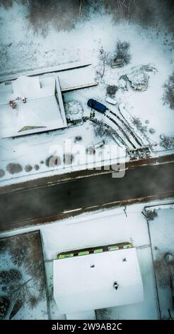 Foto aerea di una strada coperta di neve accanto a due Una casa a forma di macchina Foto Stock