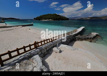 172 moli balneari che entrano nella sabbia, la spiaggia di Rilinda si affaccia sulla baia tra la terraferma e gli isolotti, il villaggio di Ksamil. Sarande-Albania. Foto Stock