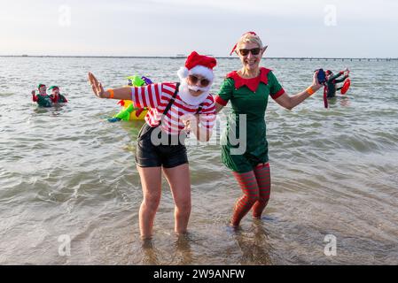 Jubilee Beach, Marine Parade, Southend on Sea, Essex, Regno Unito. 26 dicembre 2023. Come è diventata una tradizione nelle località balneari, un "tuffo di Santo Stefano" si è svolto nel freddo estuario del Tamigi a Southend on Sea vicino al molo della città, raccogliendo fondi per l'ente benefico Royal National Lifeboat Institution. Quasi 700 persone hanno preso l'acqua che è stata misurata a 7,2 gradi Celsius. Molti dei coraggiosi nuotatori indossavano costumi natalizi festivi. Gli equipaggi RNLI si sono occupati della supervisione della sicurezza Foto Stock