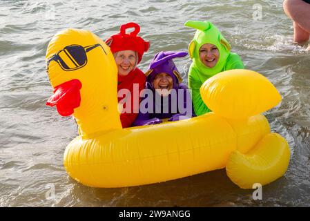 Jubilee Beach, Marine Parade, Southend on Sea, Essex, Regno Unito. 26 dicembre 2023. Come è diventata una tradizione nelle località balneari, un "tuffo di Santo Stefano" si è svolto nel freddo estuario del Tamigi a Southend on Sea vicino al molo della città, raccogliendo fondi per l'ente benefico Royal National Lifeboat Institution. Quasi 700 persone hanno preso l'acqua che è stata misurata a 7,2 gradi Celsius. Molti dei coraggiosi nuotatori indossavano costumi natalizi festivi. Gli equipaggi RNLI si sono occupati della supervisione della sicurezza Foto Stock