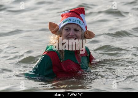 Jubilee Beach, Marine Parade, Southend on Sea, Essex, Regno Unito. 26 dicembre 2023. Come è diventata una tradizione nelle località balneari, un "tuffo di Santo Stefano" si è svolto nel freddo estuario del Tamigi a Southend on Sea vicino al molo della città, raccogliendo fondi per l'ente benefico Royal National Lifeboat Institution. Quasi 700 persone hanno preso l'acqua che è stata misurata a 7,2 gradi Celsius. Molti dei coraggiosi nuotatori indossavano costumi natalizi festivi. Gli equipaggi RNLI si sono occupati della supervisione della sicurezza Foto Stock