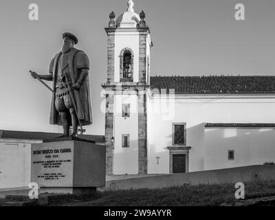 Statua di Dom Vasco da Gama con Igreja Matriz do Salvador de Sines chiesa cattolica nella città di Sines nella regione portoghese di Costa Azul Foto Stock