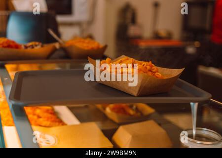 Tradizionale penne biologiche preparate al momento in salsa di pomodoro con pollo, pomodori al caffè della città o in un negozio di pasta locale a Pisa, Italia Foto Stock