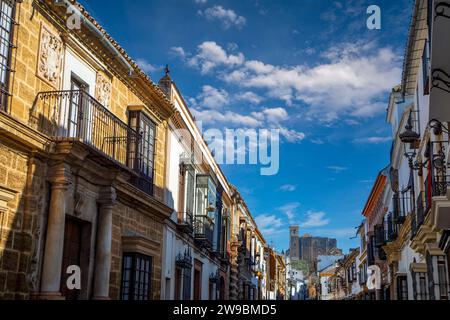 Spettacolare e storica strada di Siviglia a Osuna, Siviglia, Andalusia, Spagna, con la chiesa collegiata sullo sfondo su una collina Foto Stock