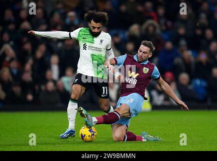 Mohamed Salah del Liverpool (a sinistra) viene affrontato dal Burnley Charlie Taylor durante la partita di Premier League a Turf Moor, Burnley. Data immagine: Martedì 26 dicembre 2023. Foto Stock